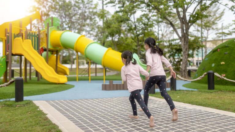 Asian little girl enjoys playing in a children playground, Outdoor portrait