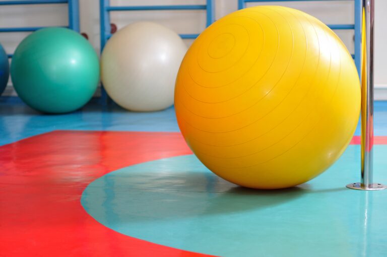 Fitness balls green, yellow and white colors located on floor in the gym. Yoga sports equipment