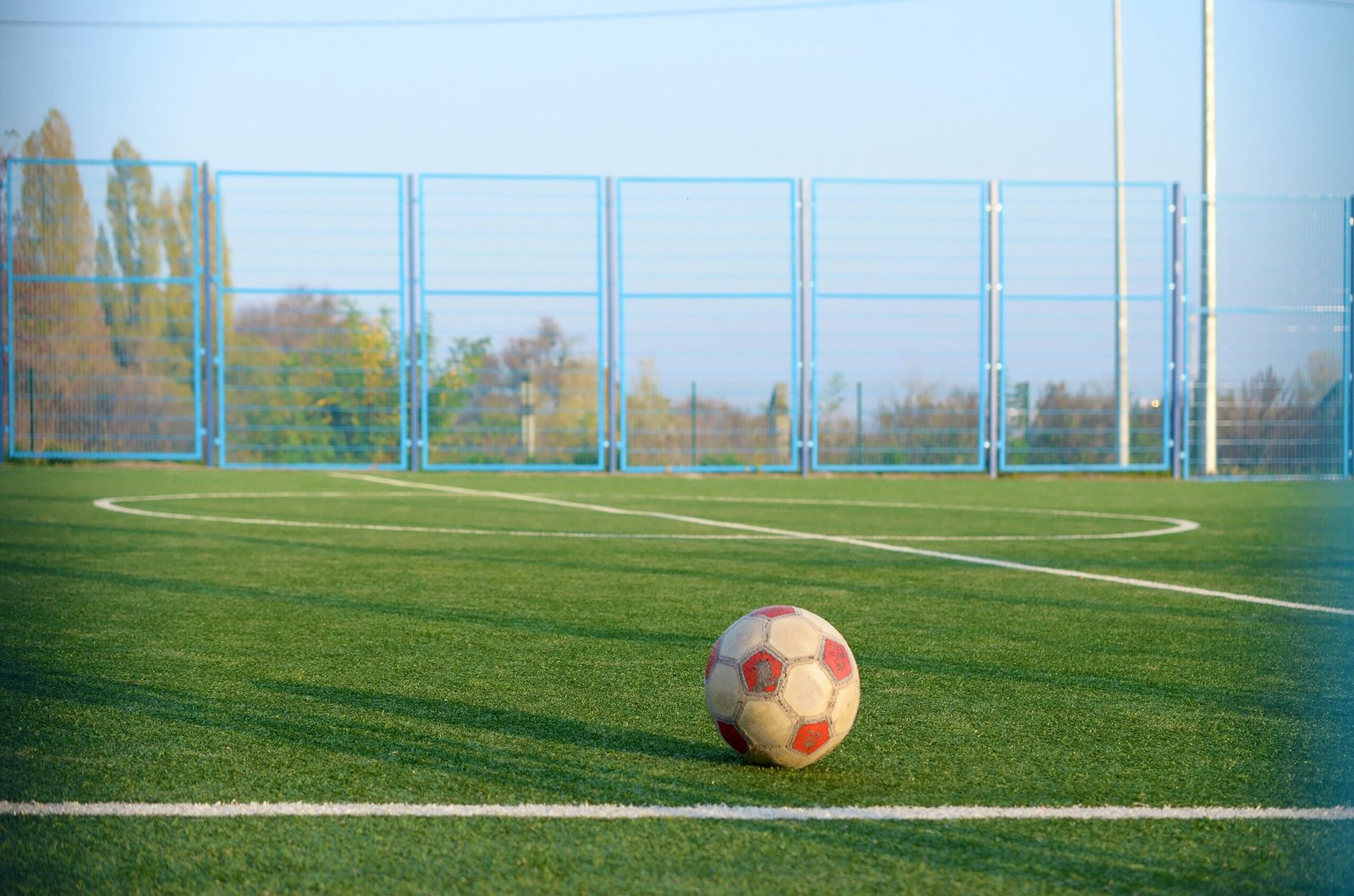 Classic soccer ball on football green grass field outdoor. Active sports and physical training concept