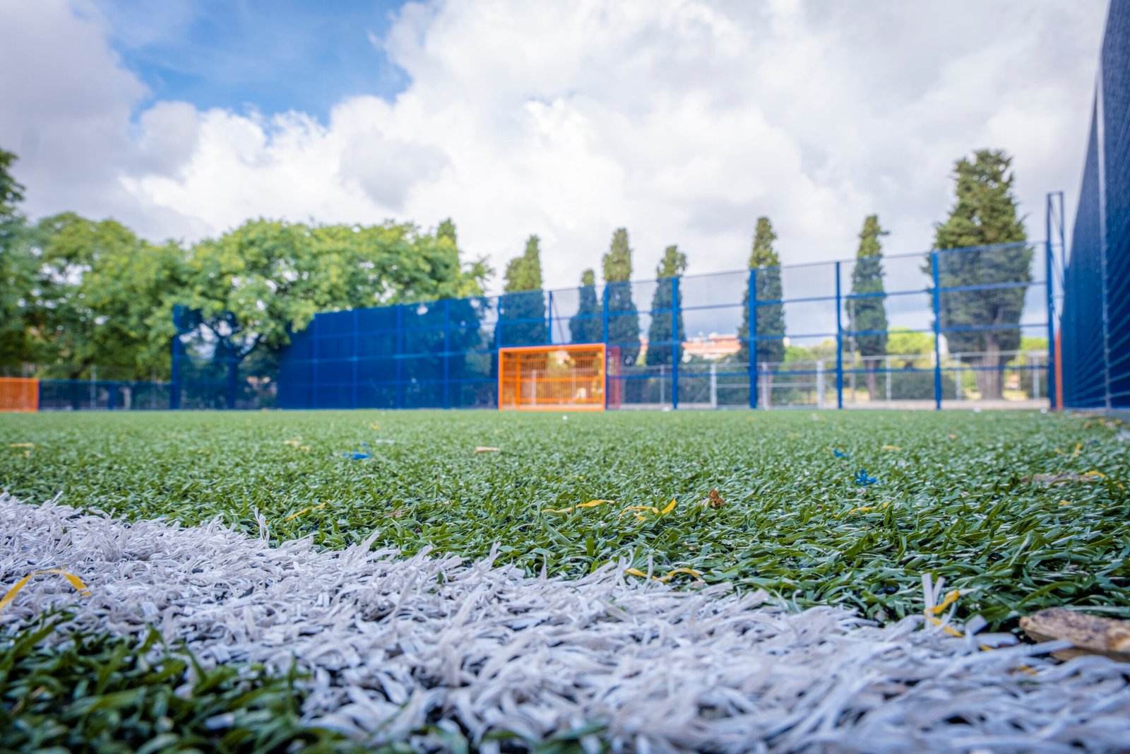Close-up of the artificial grass of a soccer field With the goal out of focus in the background.