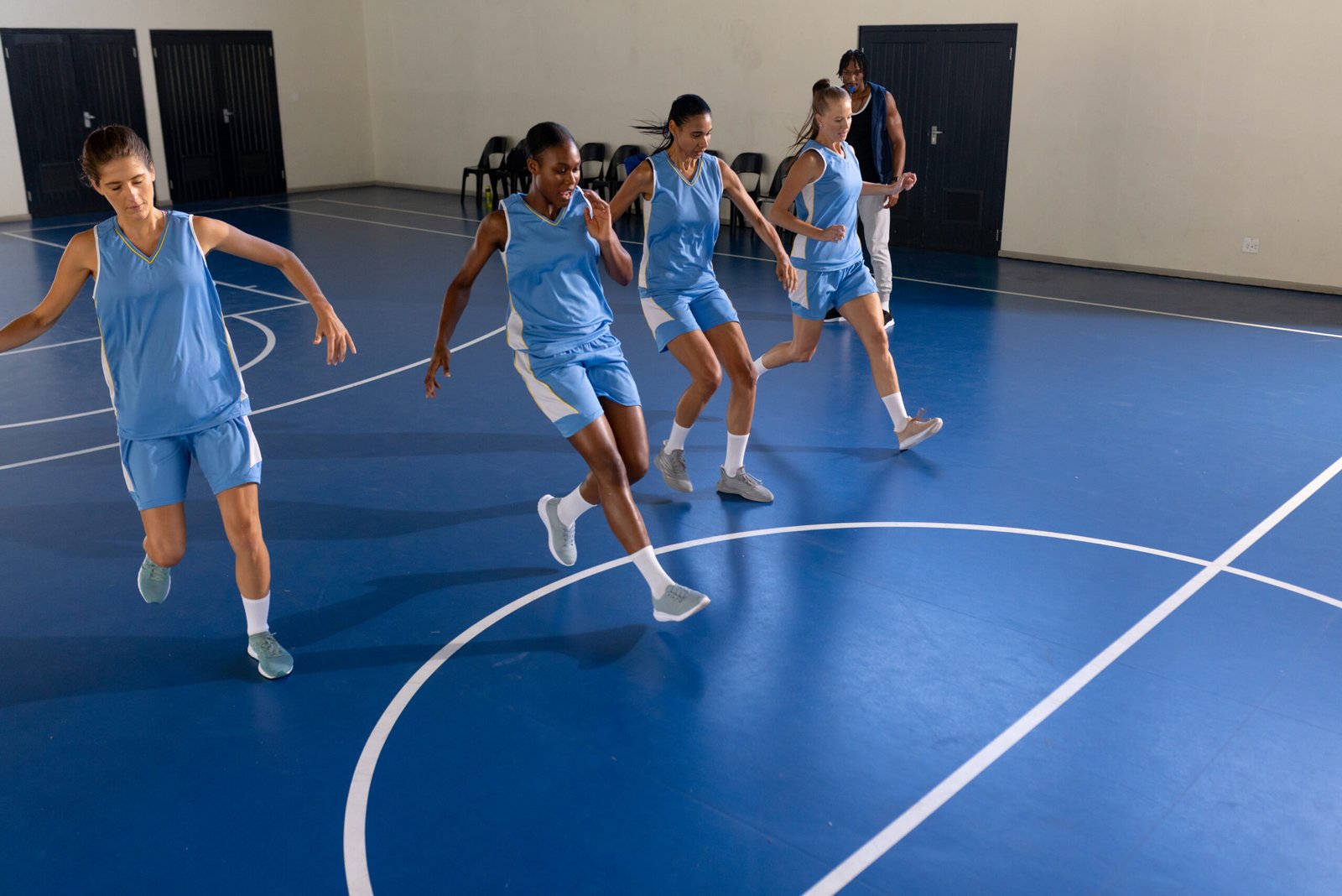 Female basketball team practicing drills on indoor court, focusing on coordination, copy space. teamwork, practice, exercise, training, athletics, fitness
