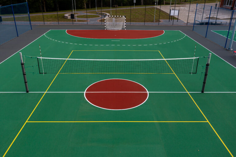 A well-maintained court designed for volleyball and handball, showing vibrant markings.