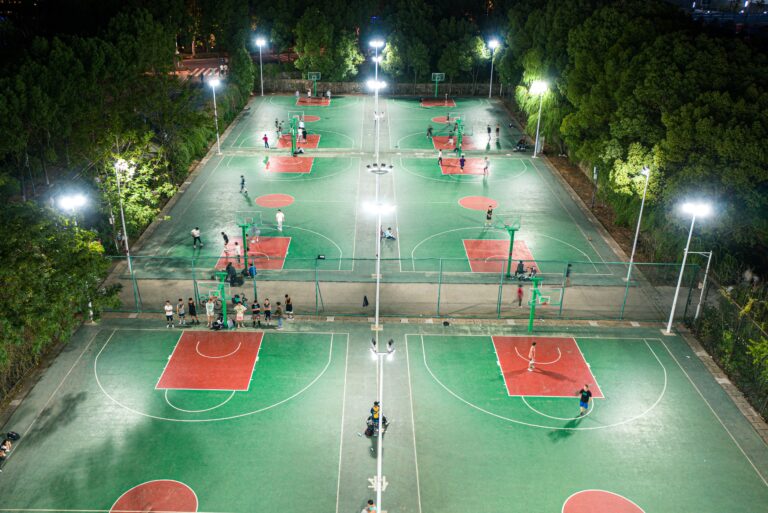 Aerial view of a professional basketball court illuminated at night in a suburban area