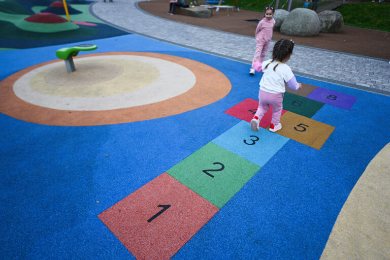 Little girl playing hopscotch game in park. Early education concept